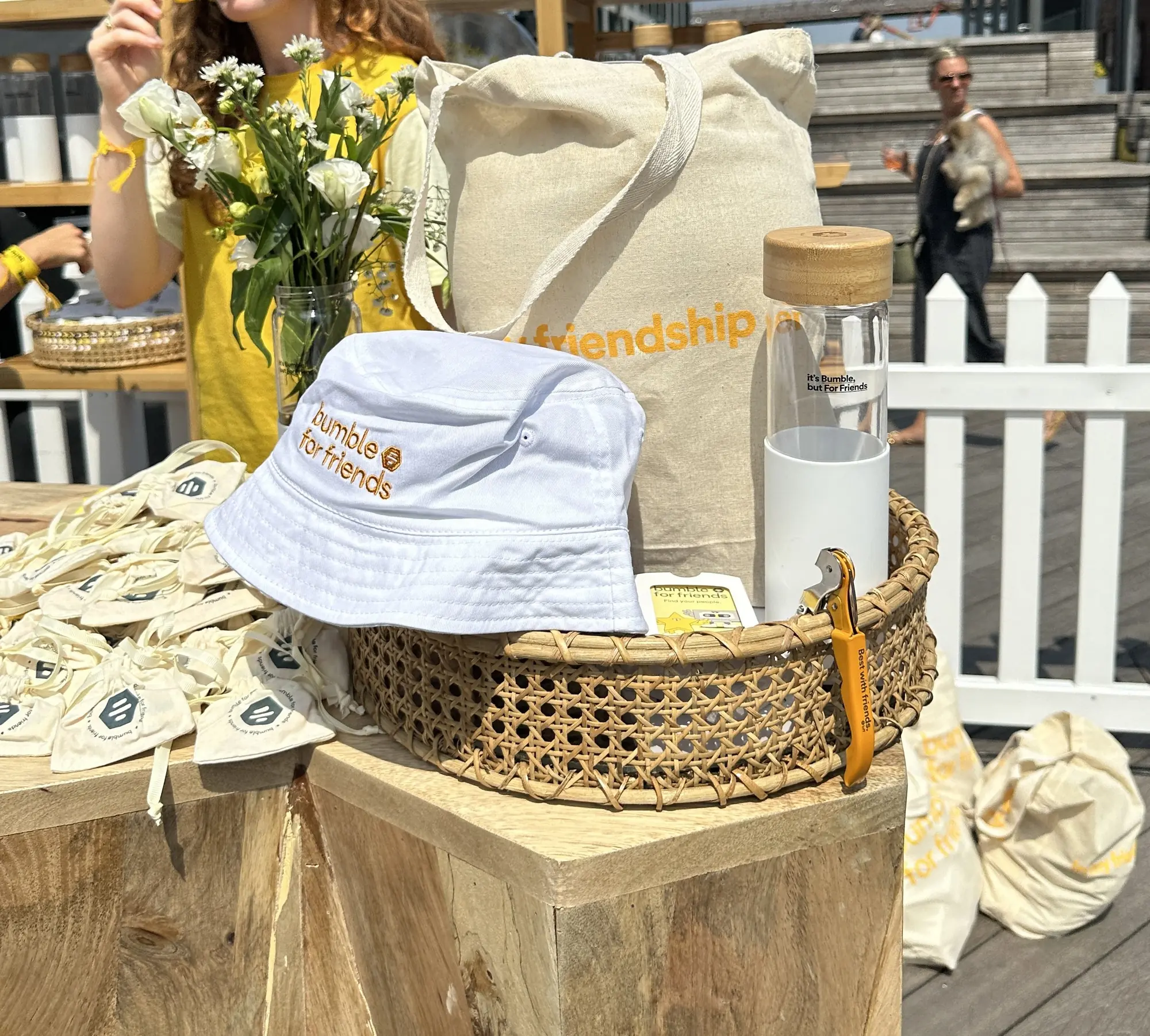 Bumble For Friends tote bag, bucket hat and bottle at a launch event